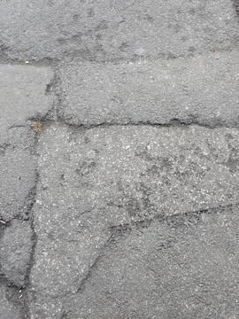 Weathered texture of dark asphalt patch Stock Photos