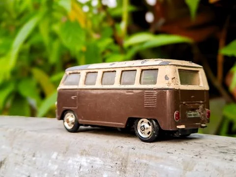 Weathered van bus model, iconic shape, retro charm. Lush green background, .. Stock Photos