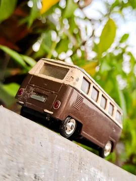 Weathered van bus model, iconic shape, retro charm. Lush green background, .. Stock Photos