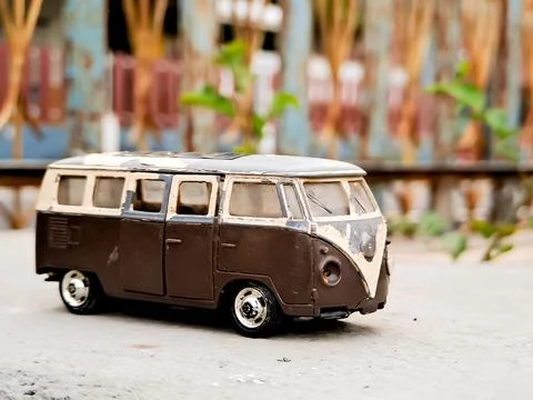 Weathered van bus model, iconic shape, retro charm. Lush green background, .. Stock Photos