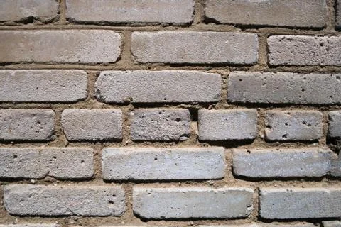 Weathered wall of old building made of grey bricks Stock Photos