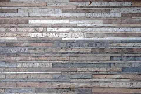 A weathered wall surface constructed from horizontally stacked irregular stone Photos
