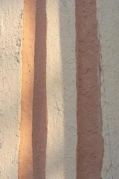 Weathered wall surface showing vertical stripes of cream and dusty pink Stock Photos