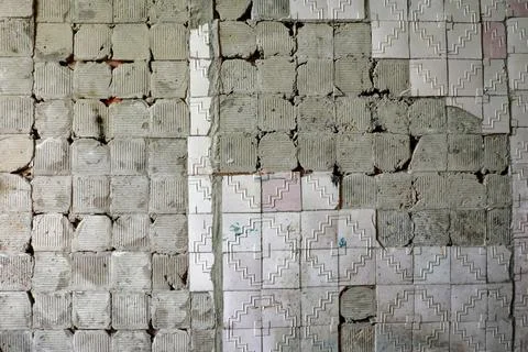 A weathered wall with a zigzag pattern, showing signs of decay and damage. 스톡 사진