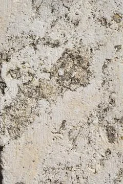 Weathered white stone wall texture with dark patches Stock Photos