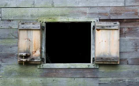 Weathered window frame with open shutters on a wooden building Stock Photos