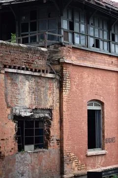 Weathered windows and brick facade of an abandoned historic building Stock Photos