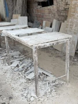 Weathered workbench with stone debris in rustic workshop, suitable for back.. Foto stock