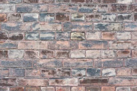 A weathered worn red stone wall in closeup Stock Photos