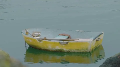Weathered yellow dinghy in the mist Stock Footage 331875269