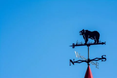 Weathervane in the form of a bear. Side of the world against the sky Stock Photos
