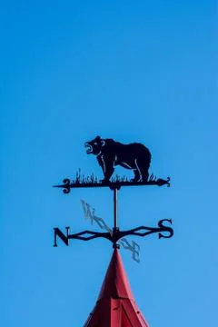 Weathervane in the form of a bear. Side of the world against the sky Stock Photos