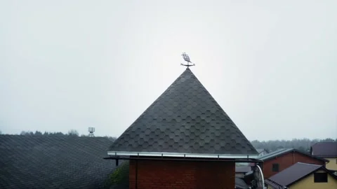 A weathervane in the shape of a ship on the spire of the tower of a red brick Stock Footage 220632453
