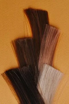 Weaved pattern made of dyed hair locks. Samples in hairdressing salon on oran Stock Photos