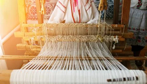 Weaver creating traditional textiles at a loom in a cultural workshop Stock Photos