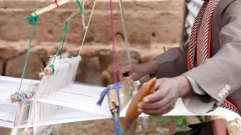 A weaver makes cloth on a hand loom in a small village in Ethiopia. Stock Footage 313503769