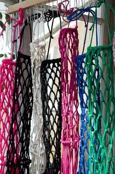 Weaving macrame from cotton thread. Colored items on display. Stock Photos