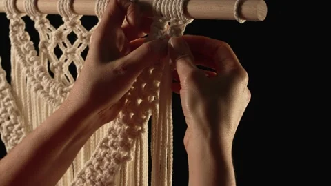 Weaving macrame pattern from natural white cotton threads. Women's hands knit Stock Footage 172241581