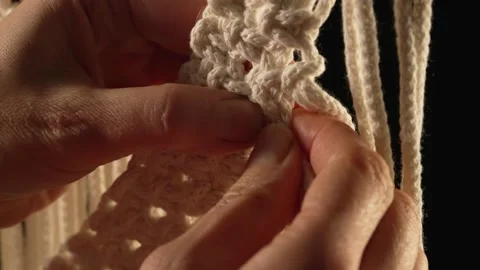 Weaving macrame pattern from natural white cotton threads. Women's hands knit Stock Footage 172241786