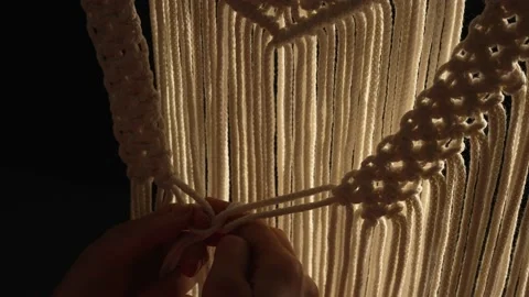 Weaving macrame pattern from natural white cotton threads. Women's hands knit Stock Footage 172242062