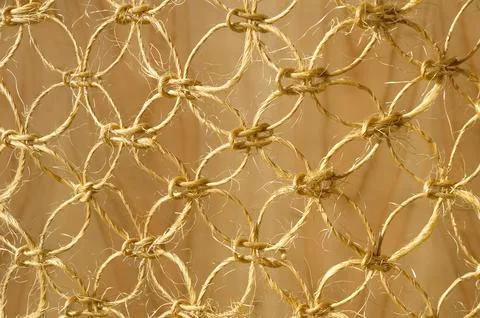 Weaving macrame from straw thread on a wooden background. Stock Photos