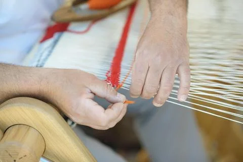 Weaving Orange Yarn Pattern on White Warp Threads with Handloom Foto stock