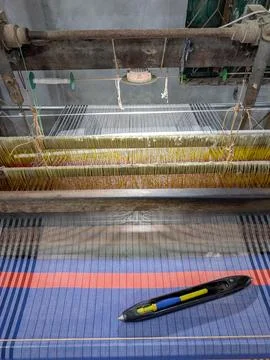 Weaving process taking place on a traditional loom with colorful threads an.. Stock Photos