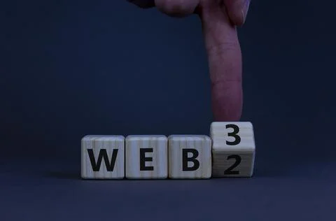 WEB 2 or 3 symbol. Businessman turns a wooden cube and changes words WEB 2 to 库存照片