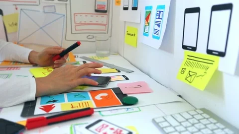 Web designer is developing an application for mobile phones.  Stock Footage 115972854