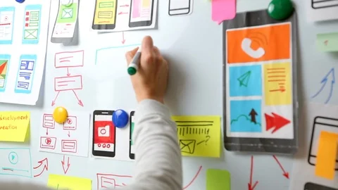 A web designer is developing a user interface for mobile phone applications.  Stock Footage 122393106