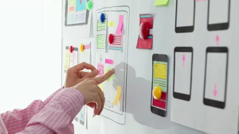 Web designer develops user interface for mobile phones.   Stock Footage 156804115