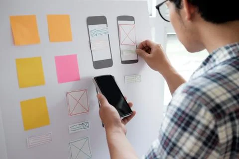 Web designer planning application for mobile phone Foto stock