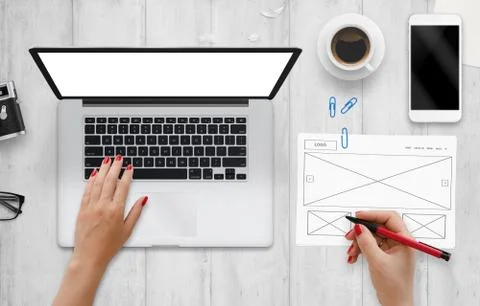 Web designer work on computer and draw idea of web site on paper. Top view of Stock Photos