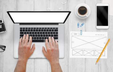 Web designer work on computer. Plan of web site drawn on paper. Top view of w Stock Photos