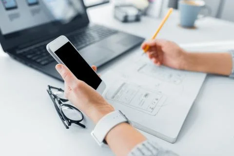 Web designer working on smartphone user interface 스톡 사진