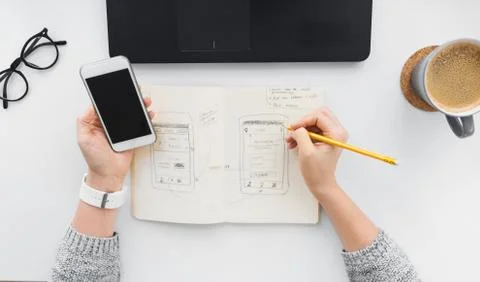 Web designer working on smartphone user interface Stock Photos