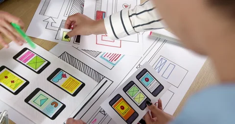 Web designers are developing a smartphone interface. Engineers create sketches  Stock Footage 201743079