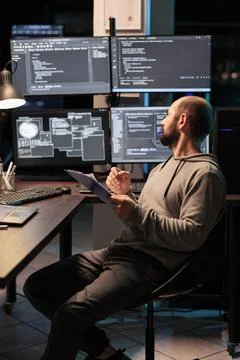 Web developer comparing data on papers Stock Photos