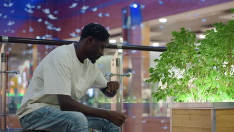 Web Developer Sitting in Mall Checking Time While Waiting Stock Footage 319919968