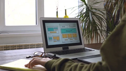 Web developer sitting at the table making a sketch of the future site. Working Vídeo Stock 87880091