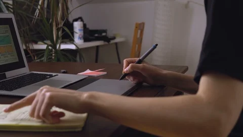 Web developer sitting at the table making a sketch of the future site. Working Stock Footage 87880254
