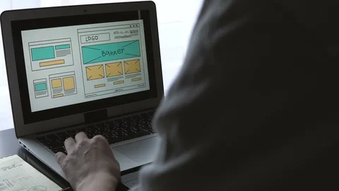 Web developer sitting at the table making a sketch of the future site. Working Stock Footage 87880530