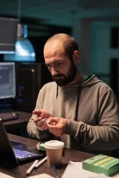 Web developer taking vitamins and working after hours Foto stock
