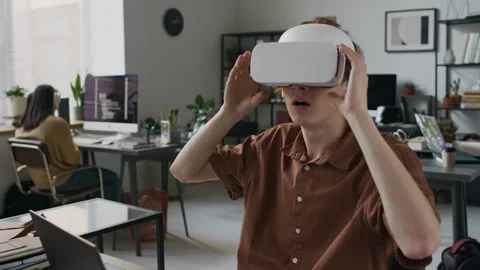 Web Developer Using VR Headset and Typing on Laptop in Office Stock Footage 299236101