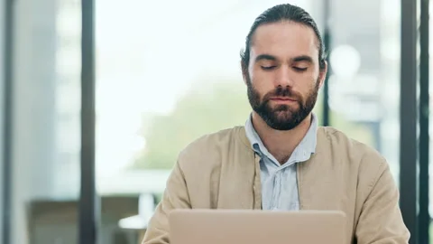 Web developer working on a laptop inside a modern office. A young, casual Stock Footage 201642256