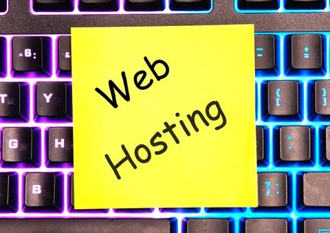 Web Hosting the phrase on the yellow sticker lies on the luminous keyboard Foto stock