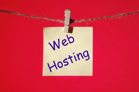 Web Hosting text on a yellow sticker on a rope with clothespins on a red back Foto stock