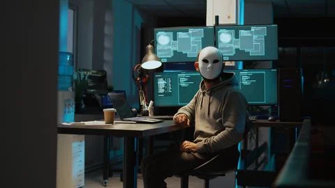 Web terrorist wearing mask hacking database servers Stock Photos
