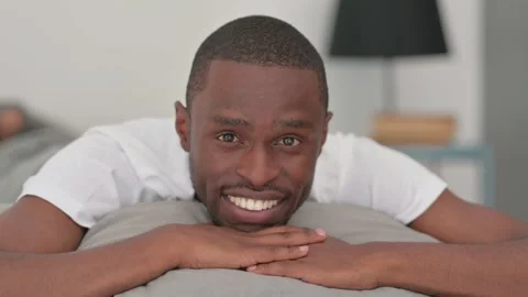 Webcam View of African Man Doing Video Chat while Lying on Stomach in Bed Stock Footage 287901299