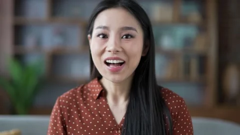 Webcam view. Amazed happy young asian woman looking surprised at camera  Stock Footage 301212772